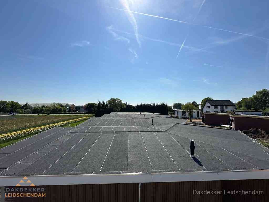 Groot plat dak met bitumen dakbedekking op bedrijfspand in Leidschendam