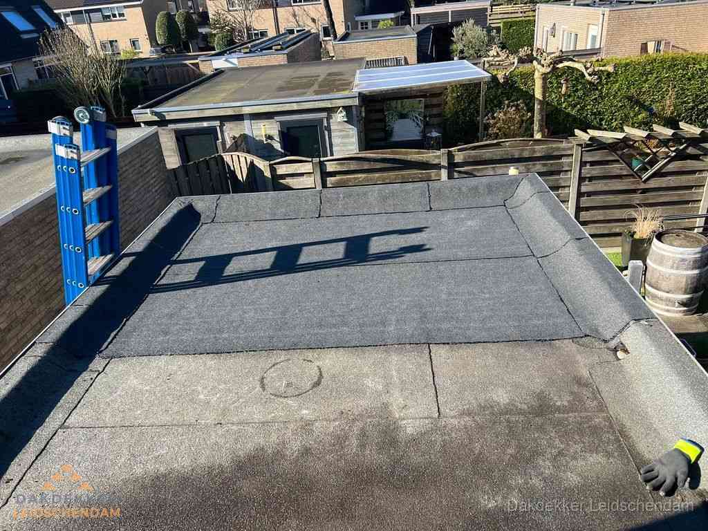Dakdekker legt onderlaag op plat dak met houten constructie in Leidschendam
