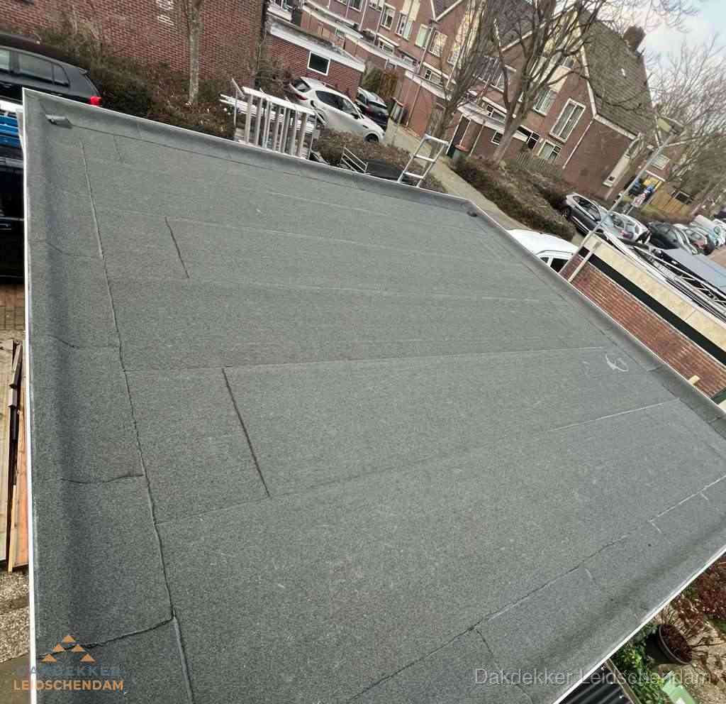 Nieuwe bitumen dakbedekking op plat dak van garage in Leidschendam