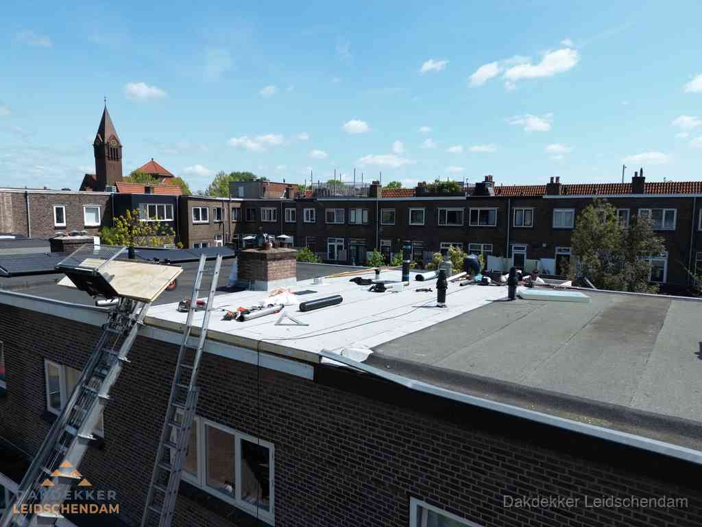 Dakdekkers aan het werk op plat dak in Leidschendam