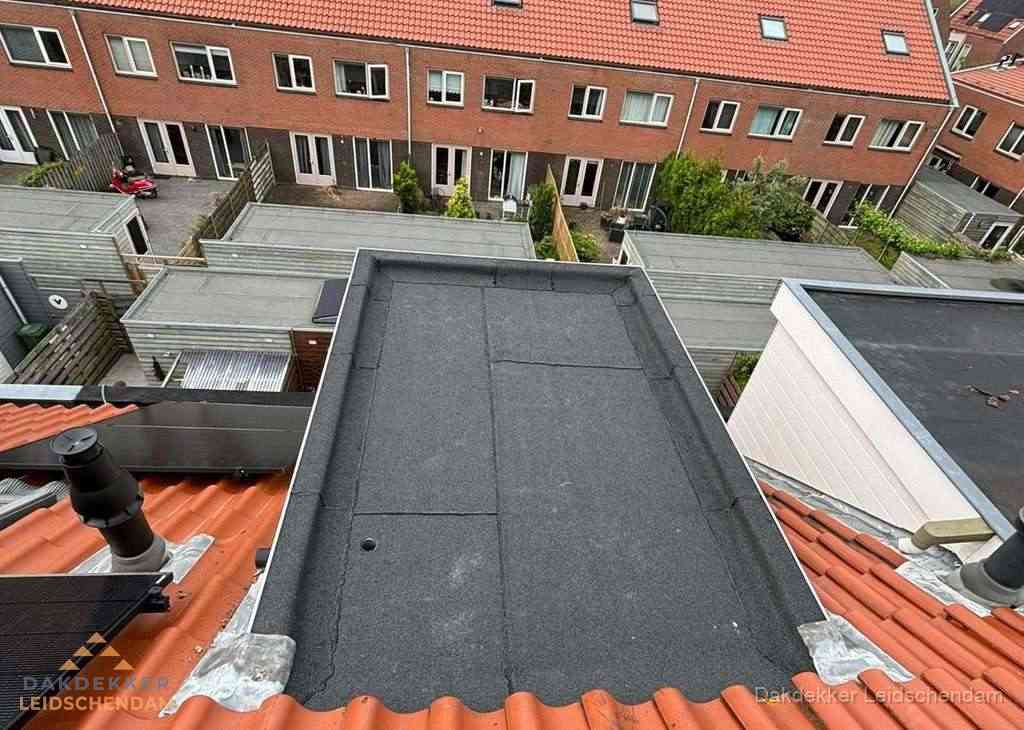 Plat dak met bitumen bedekking naast dakkapel in Leidschendam