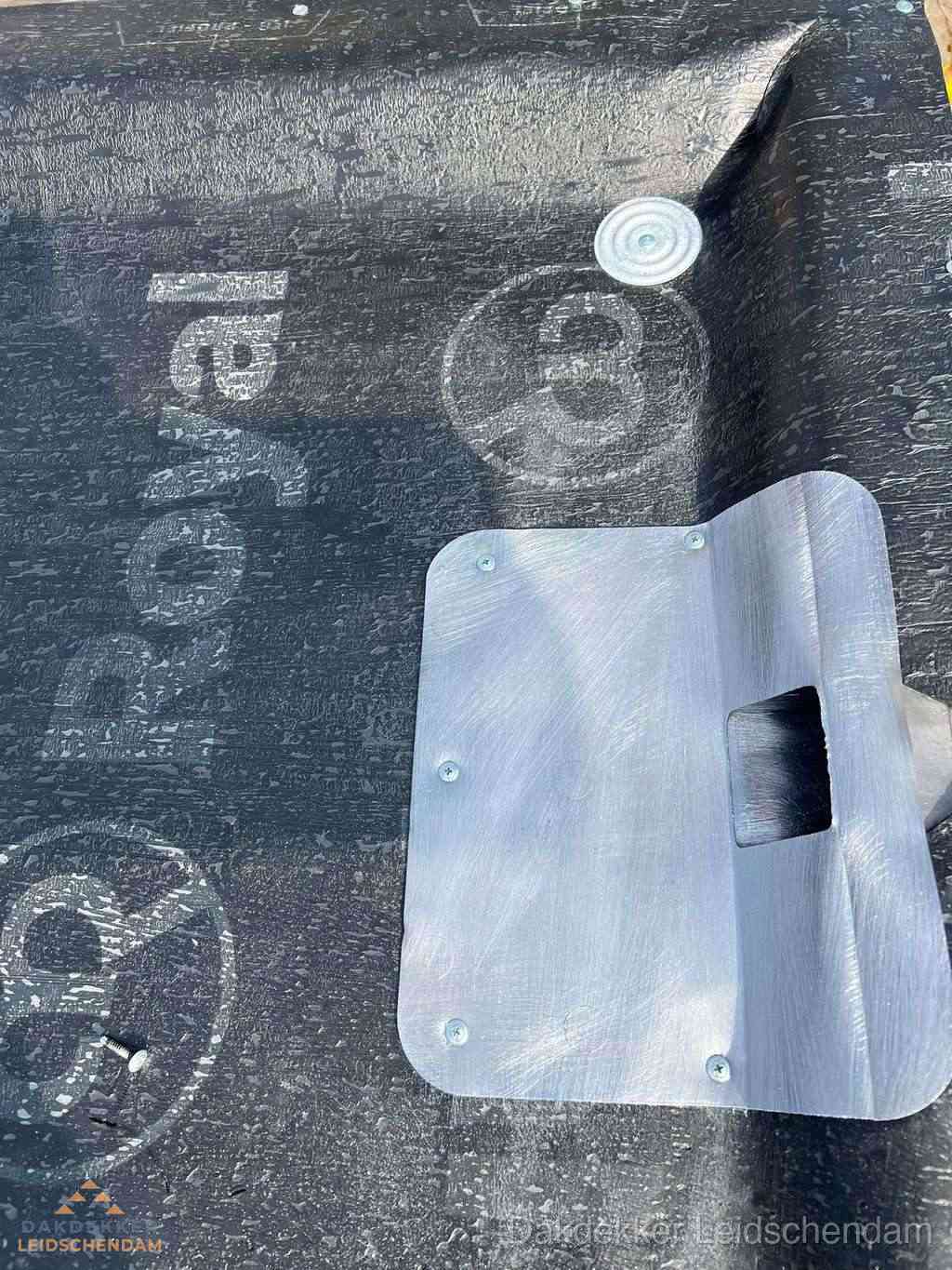 Dakdoorvoer met metalen afvoerplaat op bitumen dak in Leidschendam